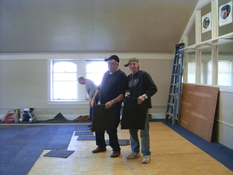 Pose de dalles de moquette dans une salle.